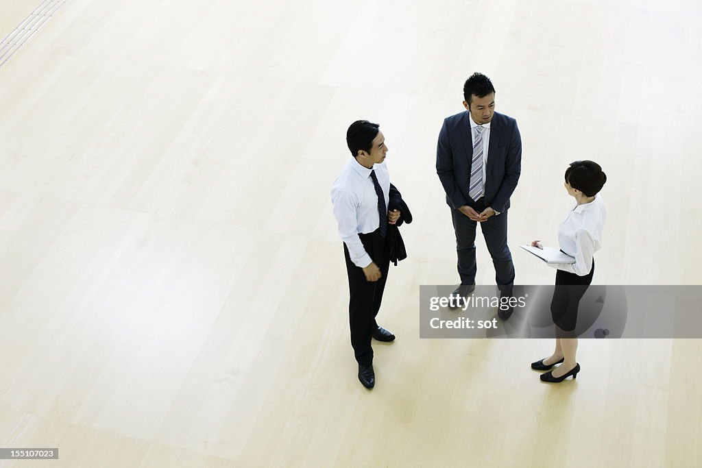 Coworkers talking in entrance hall of office