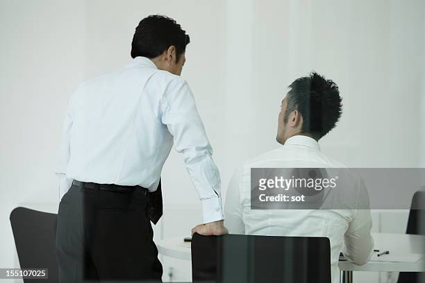 coworkers examining plans in conference room - オフィス　日本人　会議　not 多民族 ストックフォトと画像