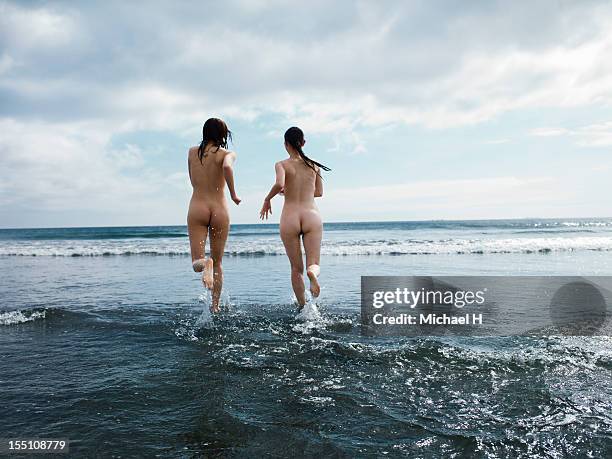 the nudes women which runs the beach - nudity foto e immagini stock