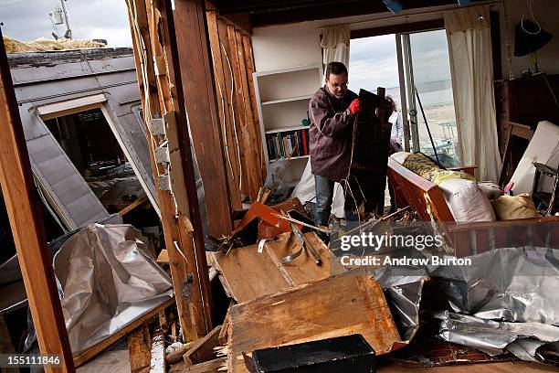 Eric Lenz helps clean out a friend's trailer after it was destroyed by Superstorm Sandy on November 1, 2012 in Highlands, New Jersey. Superstorm...