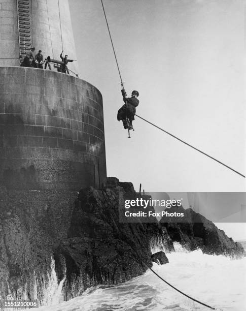 Bishop Rock Lighthouse Keeper Mr Freethy is hoisted onto a boat after bad weather, Scilly Islands, March 26th 1936.