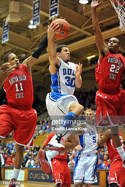 Seth Curry of the Duke Blue Devils goes to the hoop against Justin Glover and WyKevin Bazemore of the Winston-Salem State Rams at Cameron Indoor...