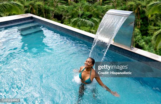 hermosa mujer relajándose en la piscina en un spa - black massage therapist fotografías e imágenes de stock