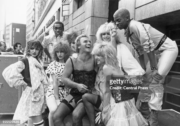 English comedian Freddie Starr poses in London with British dance troupe Hot Gossip, 27th March 1981. Starr is embarking on a British theatre tour...