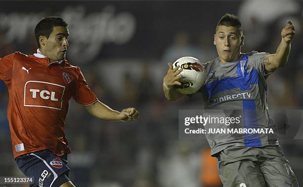 Chile's Universidad Catolica forward Kevin Harbottle controls the ball helped with his hand next to Argentina's Independiente defender Gabriel Valles...