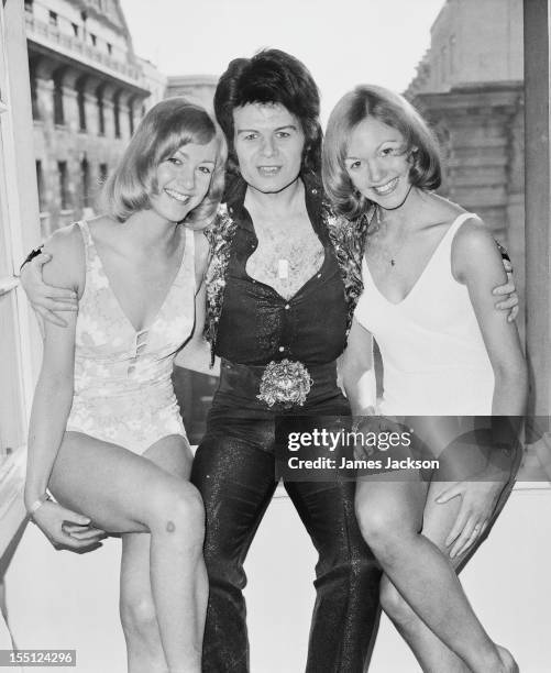 English pop singer Gary Glitter with Miss Great Britain, Gay Spink, right) and her sister Zoe at the Waldorf Hotel, London, 15th March 1973.