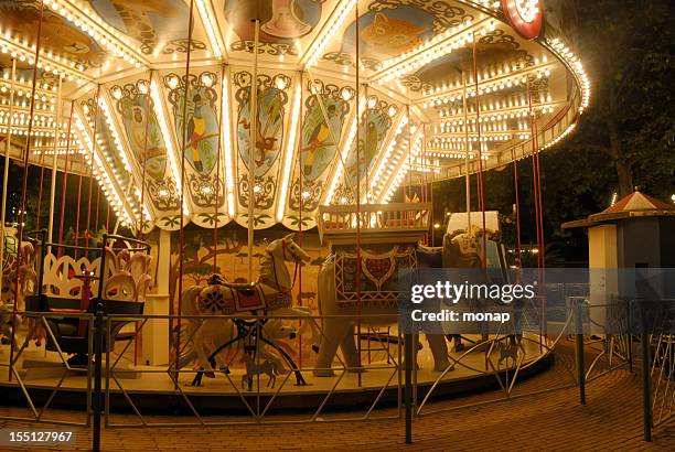 karussell bei nacht beleuchtet - carousel horses stock-fotos und bilder