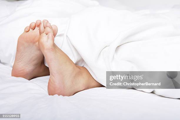 woman bare feet under blanket - bare bottom women stockfoto's en -beelden