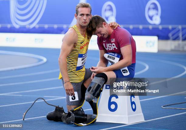 Johannes Floors of Germany consoles Hunter Woodhall of the United States after he sees his broken prosthesis before the Men's 400m T62 Final during...