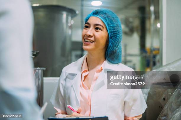 portrait of a smiling scientist holding a clipboard in the factory - rede de cabelo imagens e fotografias de stock