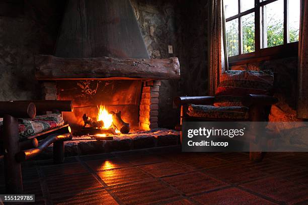 caminetto con log, sedie in legno e finestre - cottage foto e immagini stock