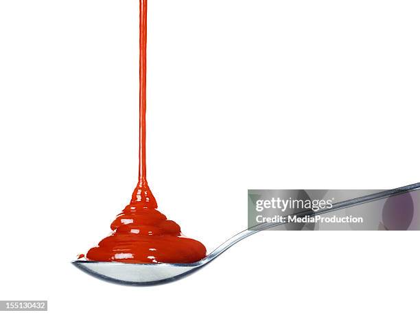 ketchup pouring on a spoon - tomatenketchup stockfoto's en -beelden