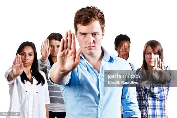 five serious young people hold up hands indicating stop - sayings stockfoto's en -beelden