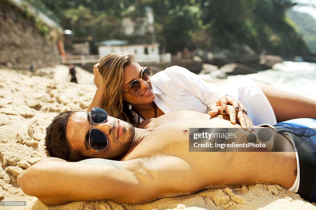 Beautiful young couple sunbathing on the beach.