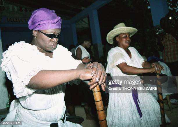 Haitian women are shown in a trance as they dance 22 November 2003, during a voodoo ceremony organised in Freres, Haiti in honor of Baron Samedi: the...