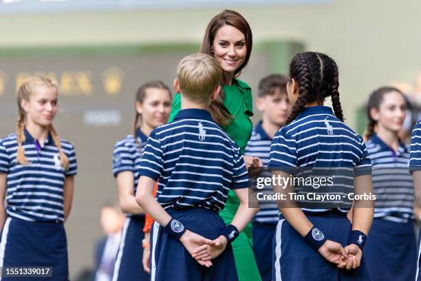 Catherine, Princess of Wales talks with ball boys and ball girls after the trophy presentation for the Gentlemen's Singles Final match on Centre...