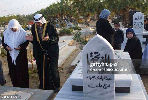 Palestinians recite the Fatiha, the opening Surat of the Koran, over the tombs of their relatives, a ritual performed by Muslims during the early...