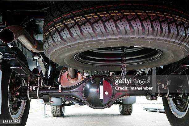 closeup small truck spare tyre attached under the vehicle - chassis stockfoto's en -beelden