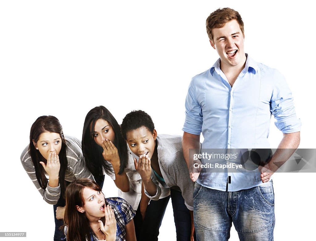 Confident, winking young man indicates his size to shocked girls