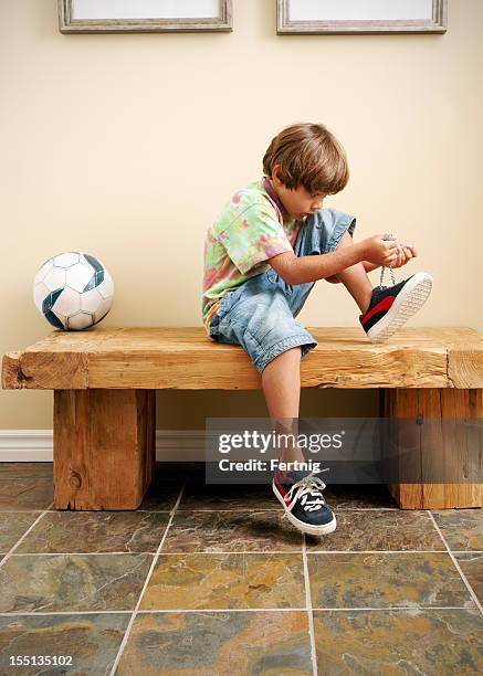 heading out to play - tying shoes stockfoto's en -beelden