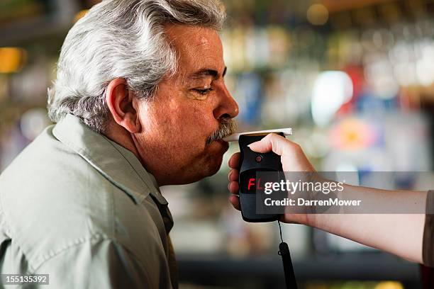 man taking a breath test held by anther person - breath test stockfoto's en -beelden