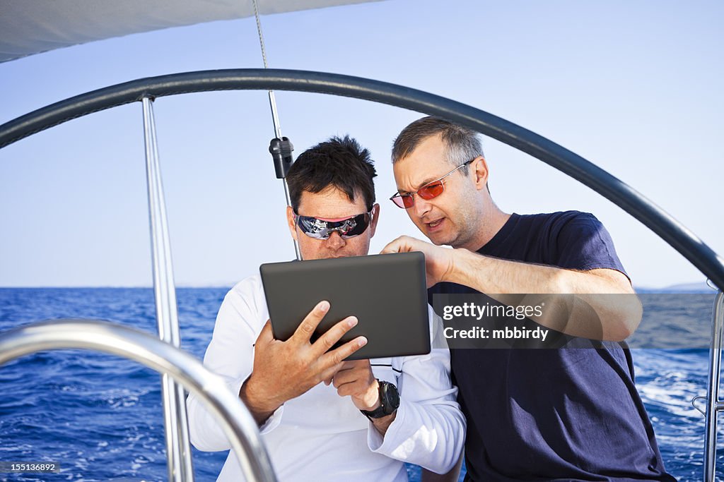 Skipper mit digitalen tablet auf Segelboot