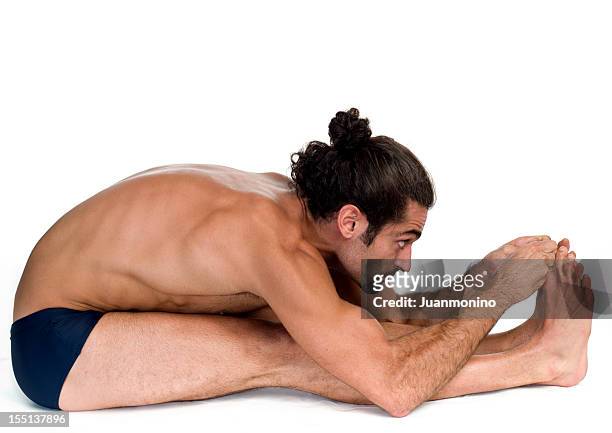 young man practicing bikram hot yoga paschimotthanasana position - bikram yoga stock pictures, royalty-free photos & images