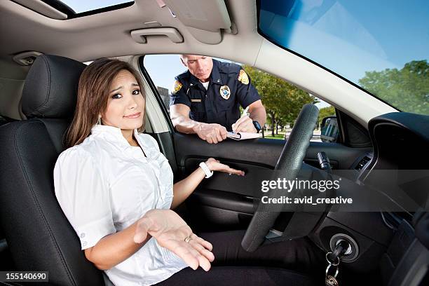 woman receiving moving violation - verkeerspolitie stockfoto's en -beelden