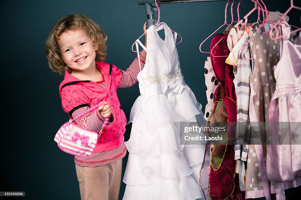 Blonde girl shopping for dresses while carrying little purse