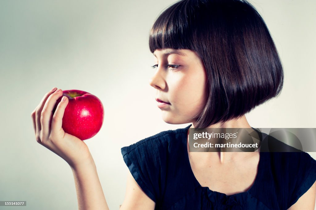 Garota prestes a comer uma maçã vermelha.