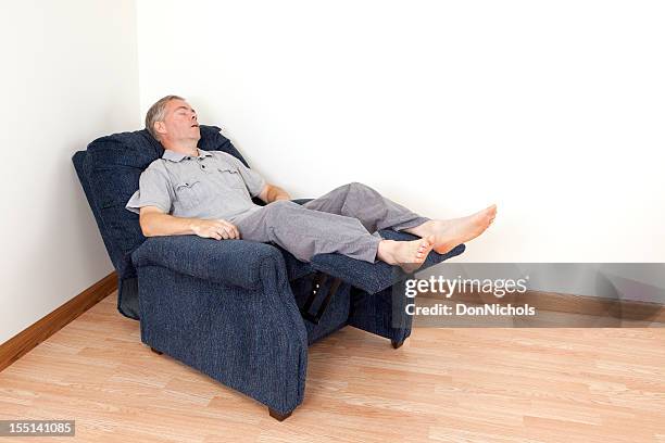 man sleeping in a recliner - recliner chair stock pictures, royalty-free photos & images