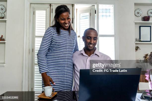 wife embracing working husband at home - antilles stock pictures, royalty-free photos & images