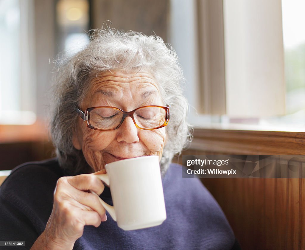 Senior Frau lustig Gesicht Lächeln mit Kaffeetasse