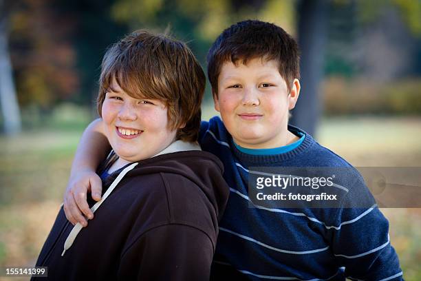 porträt von zwei süße jungs, die arme an übergewicht - chubby kid stock-fotos und bilder