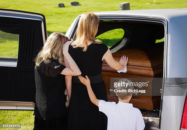 grieving family at a funeral - coffin stockfoto's en -beelden
