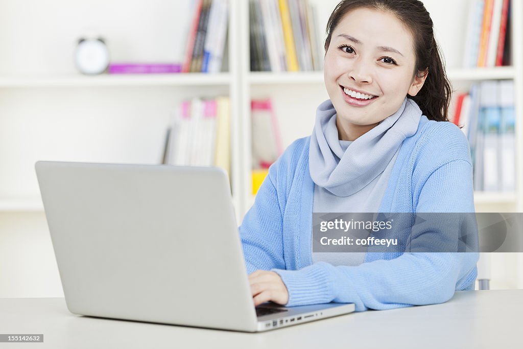 Giovane asiatica donna d'affari, lavorando con computer portatile