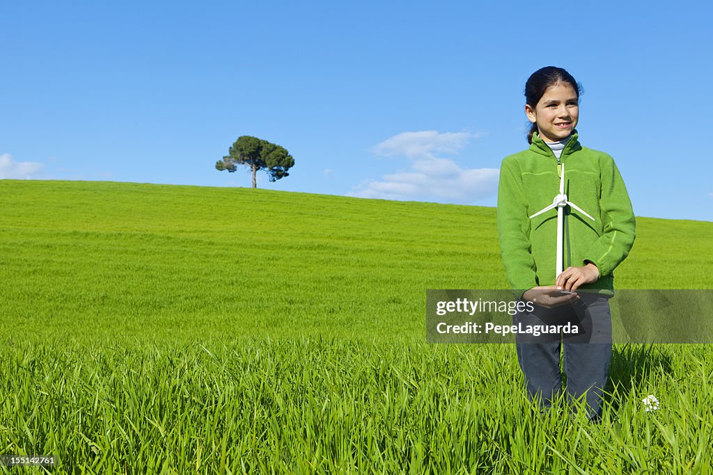 Green energy: girl holding wind turbine