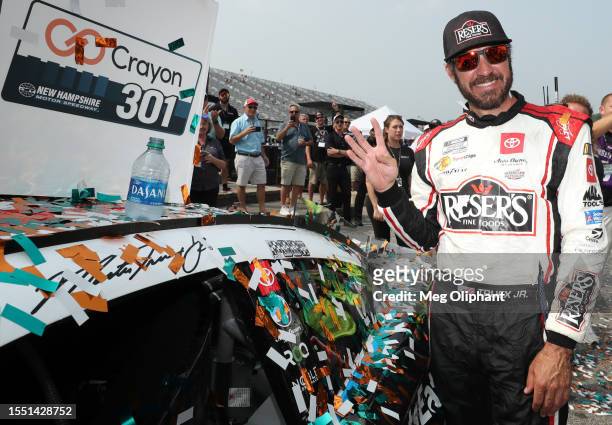 Martin Truex Jr., driver of the Reser's Fine Foods Toyota, poses next to his winner sticker in victory lane after winning the NASCAR Cup Series...
