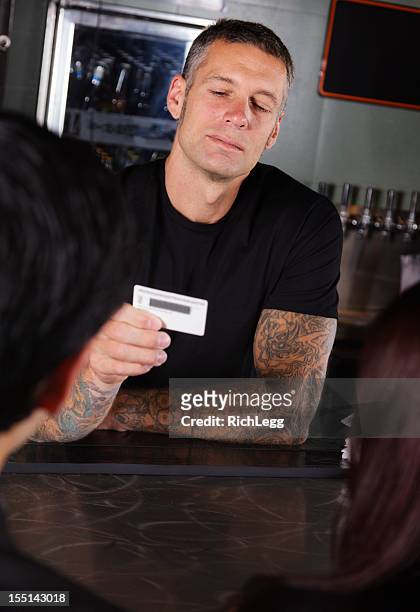 bartender checking id - id card stockfoto's en -beelden