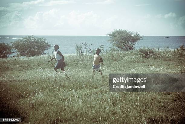 retro-look; mädchen laufen im grünen feld mit meer-landschaft - children vintage coastal stock-fotos und bilder