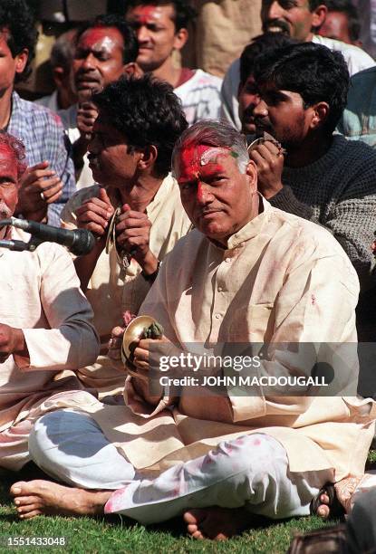 Indian Finance Minister Yashwant Sinha, splattered with colours, plays percussion with a band during a ceremony at Indian Prime Minister Atal Behari...