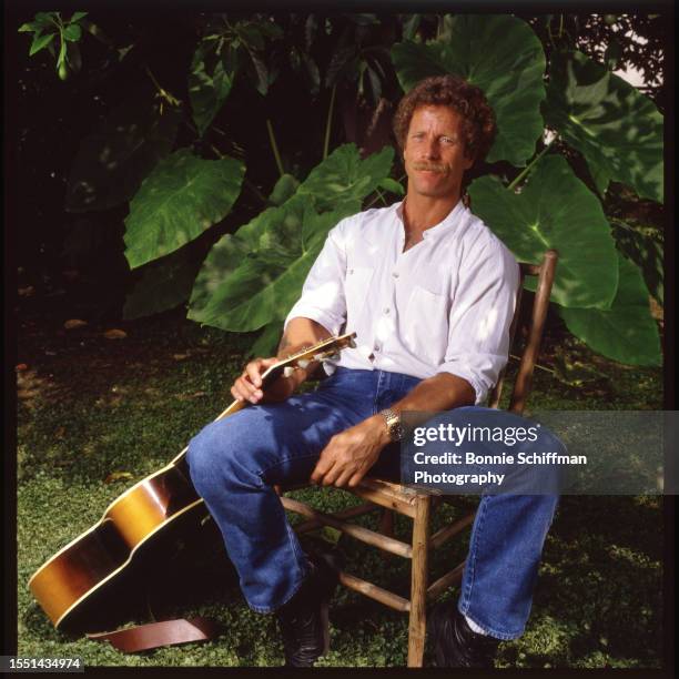 Musician Chris Hillman of The Byrds and other bands poses with an acoustic guitar outside in Los Angeles in 1980.