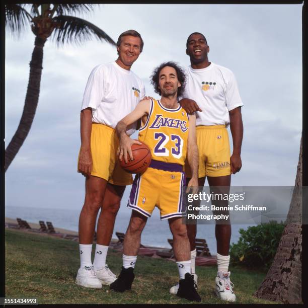 Los Angeles Lakers Jerry West and Magic Johnson and actor Harry Shearer pose in Lakers gear in front of a palm tree in Los Angeles in 1991.