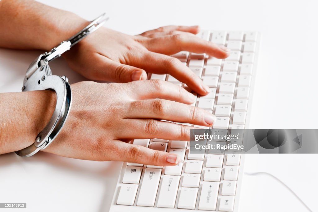 Despite being handcuffed hands type away busily on keyboard