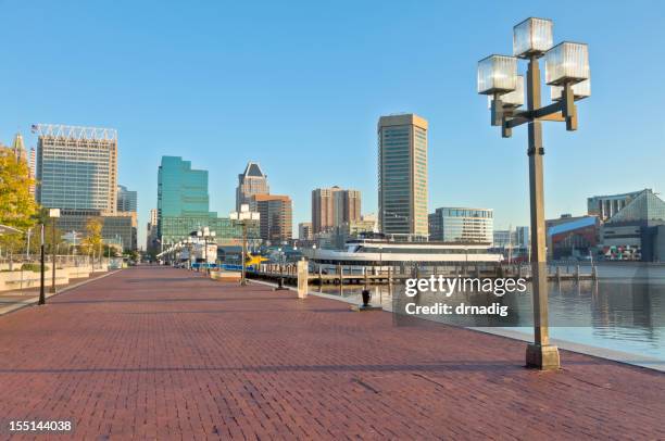 baltimore inner harbor skyline and paved waterfront promenade - inner harbor baltimore stock pictures, royalty-free photos & images
