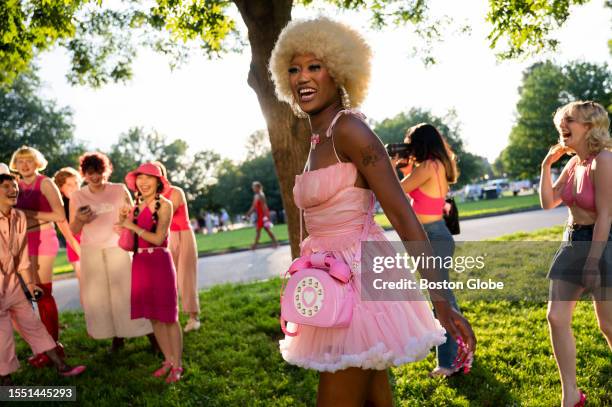 Woman smiles for the photo surrounded by a group of friends before the first night of the screening of the "Barbie" movie at the AMC movie theater at...