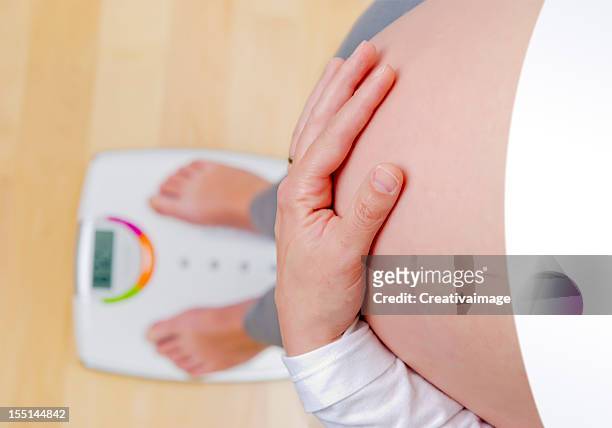 pregnant woman on the balance - mass unit of measurement stock pictures, royalty-free photos & images