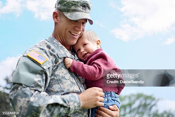 american soldier and son in a park - armed forces stock pictures, royalty-free photos & images