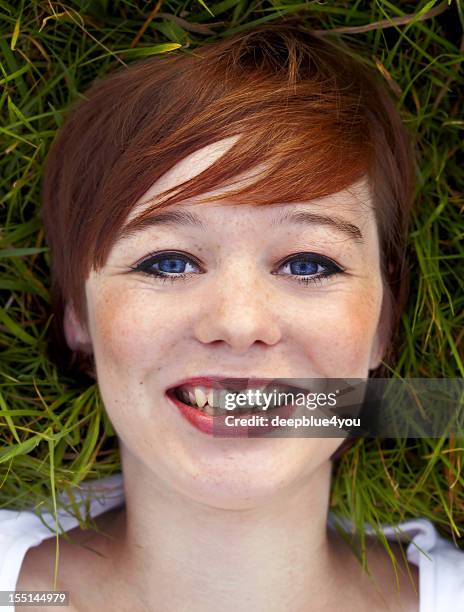 beautiful young brunette woman head on grass portrait - grass von oben stock pictures, royalty-free photos & images