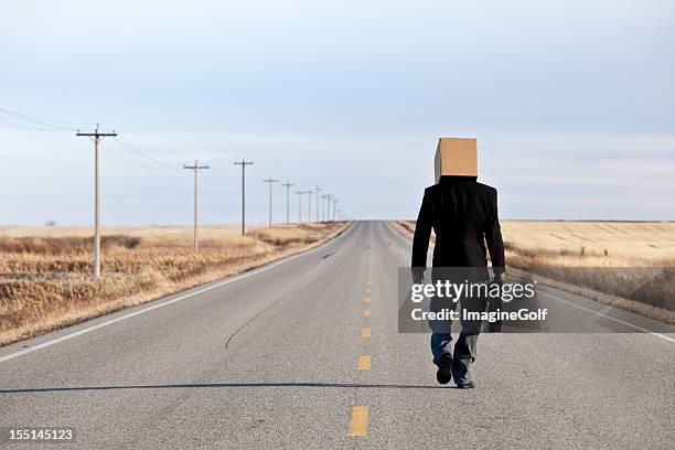 empresario triste con caja en la cabeza caminar por la autopista - in case of discomfort fotografías e imágenes de stock